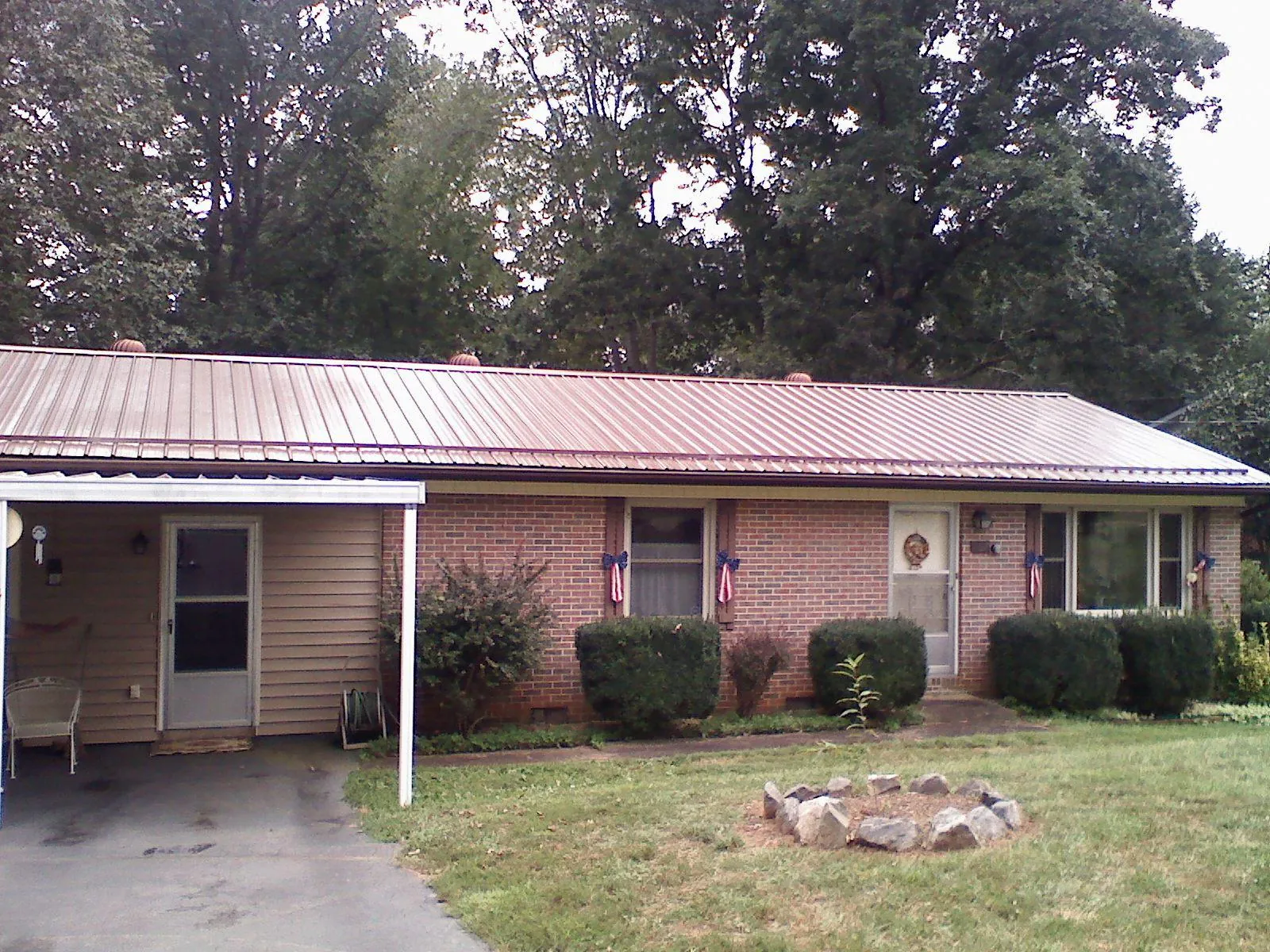 Bronze metal roof and carport on a brick ranch home — Roof Repair work by our crew in Atlantic Beach