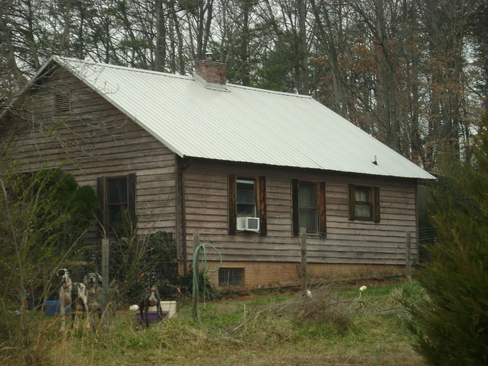 White metal roof on an old wood sided farmhouse, from a Metal Roof Installation job in Atlantic Beach